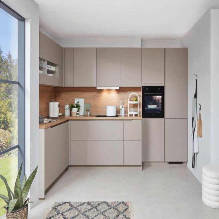 Musterküche in Kaschmir Musterküche in Kaschmir als L-Küche mit Holzrückwand und Backofen im Hochschrank – Küchenaufbau Wolfsburg